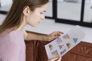 side view woman checking some statistics paper