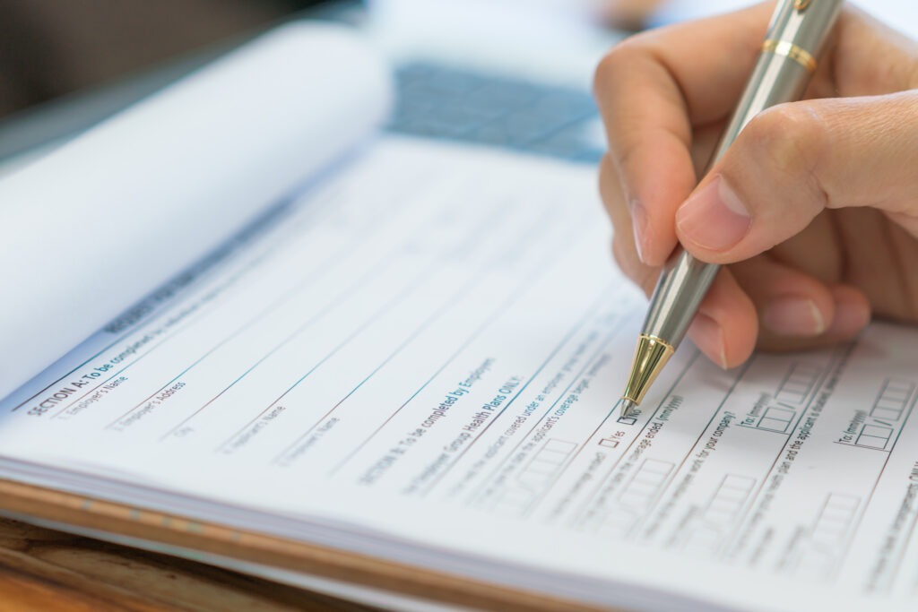 hand with pen over application form .