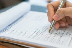 hand with pen over application form .
