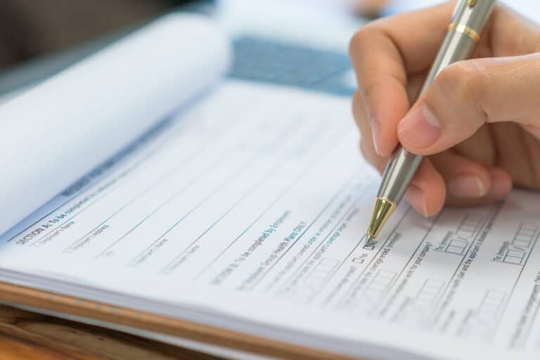 hand with pen over application form .