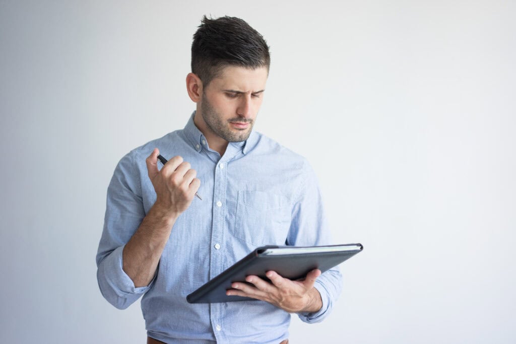 portrait of serious young businessman with folder and pen